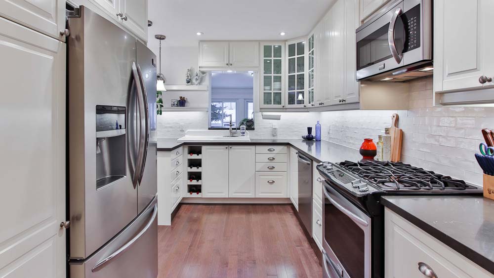 A kitchen with a built-in microwave over the oven